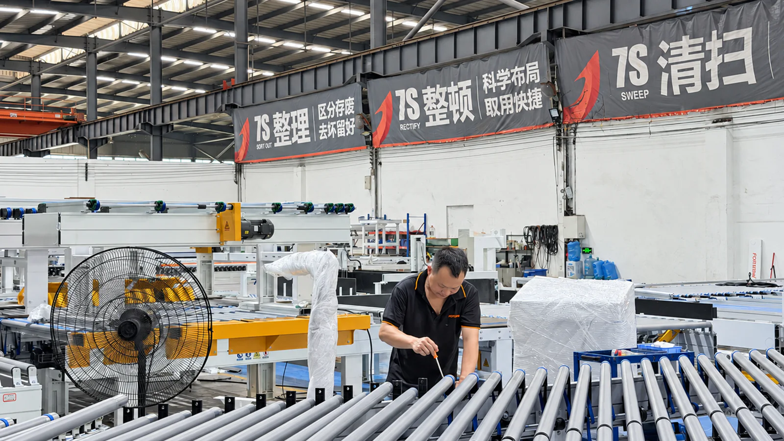 FORTRAN technician inspecting conveyor equipment during workshop commissioning